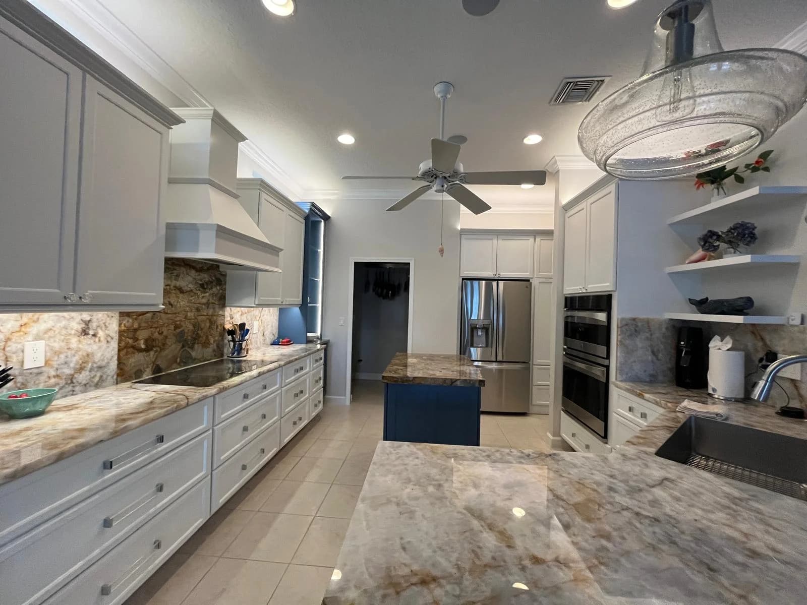 A kitchen island with dark granite counters, cleaned and organized.